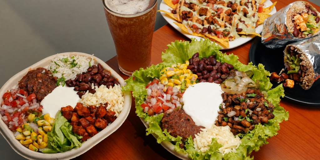 Authentic Kaazos Mexican dining feast table with bowls, wraps, and nachos